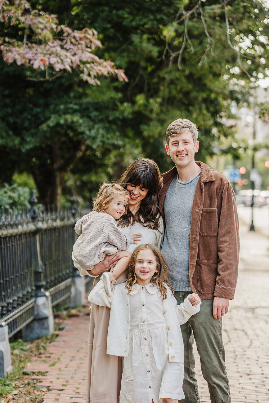 family in neutral color scheme smiles outside boston public garden