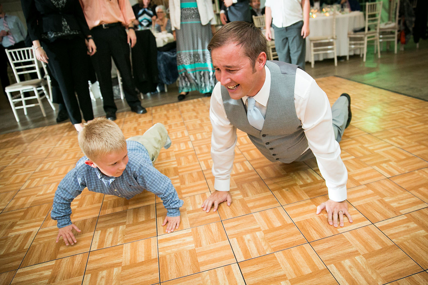 groom dancing with kids at reception