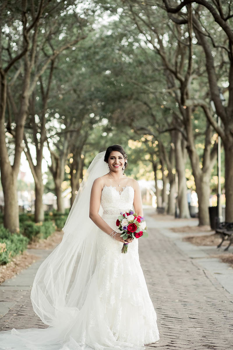 Bride stands under trees at the Waterfront Park, Charleston Wedding Photographer.