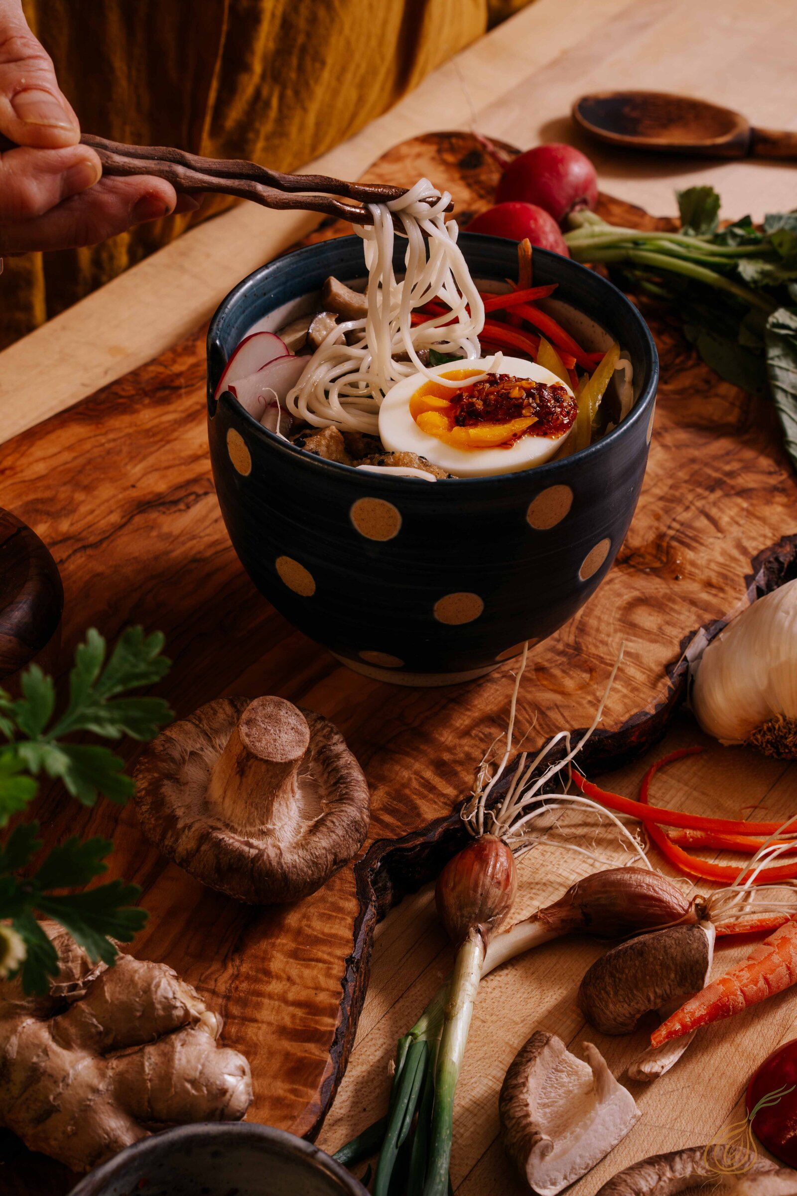 A bowl filled with colorful noodles, fresh vegetables, and aromatic herbs, showcasing a vibrant and appetizing dish.