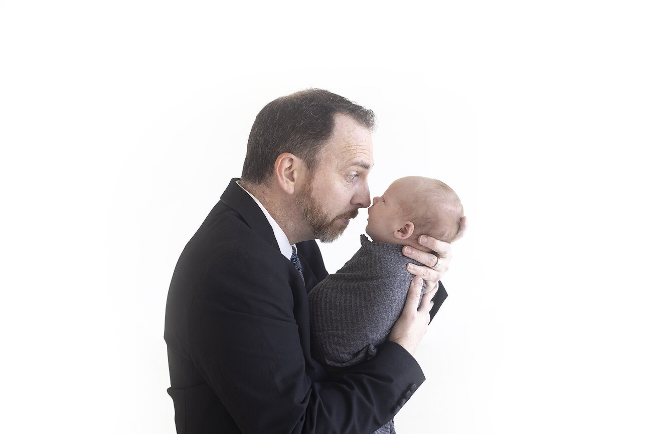 Father making silly face and newborn son.