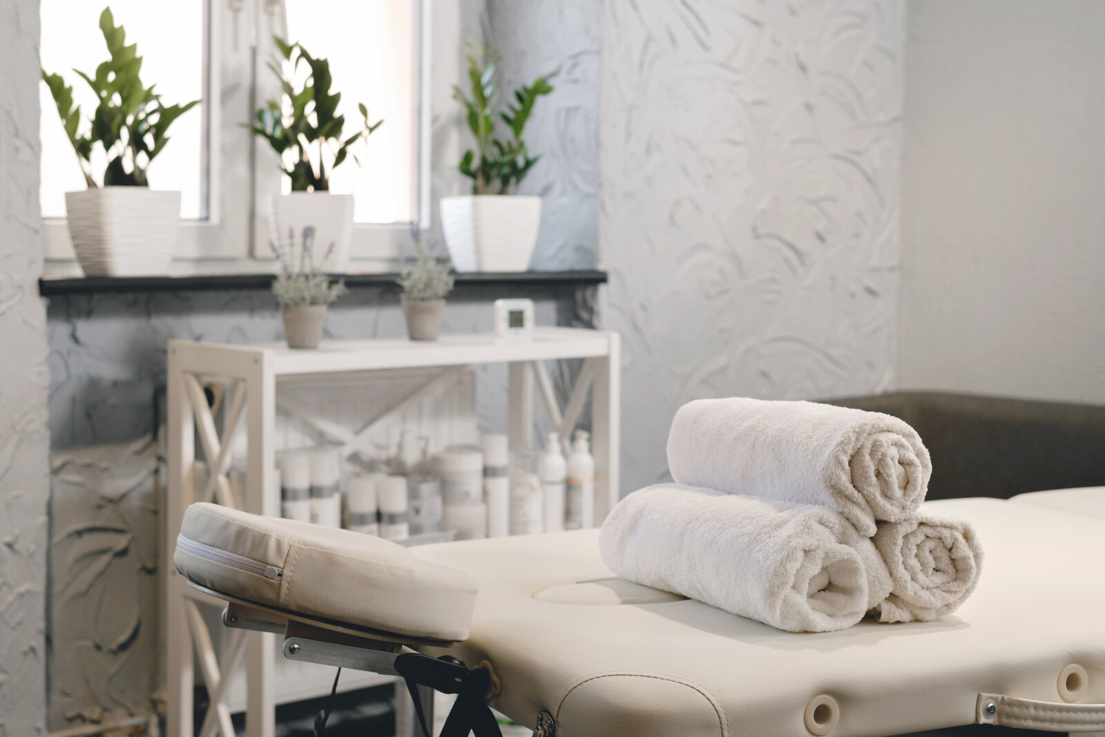 Massage table prepared with rolled white towels in a modern, clinical setting at Needle Point Therapy in Greenville, SC