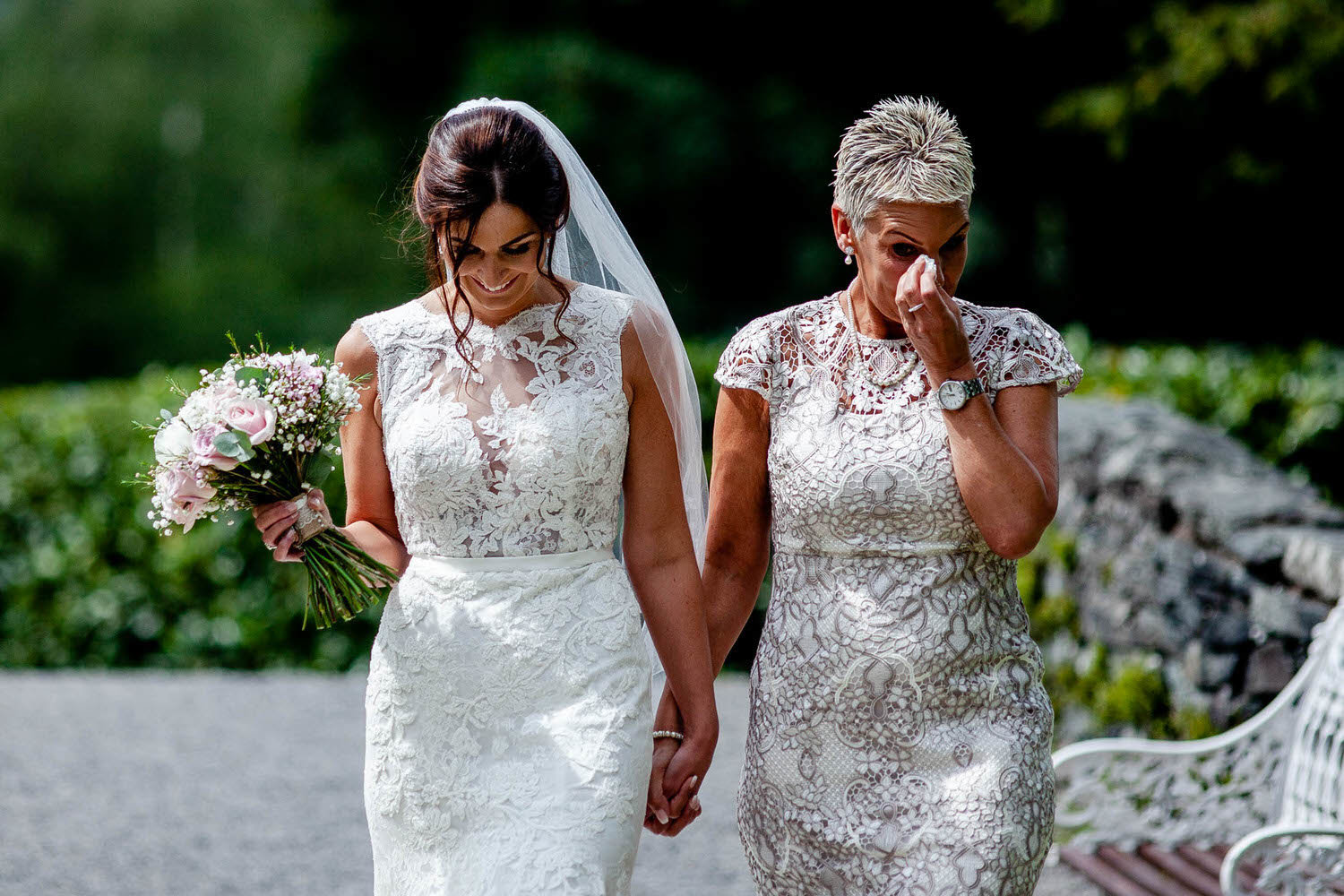 mother and bride walk down the aisle together in a lake district wedding