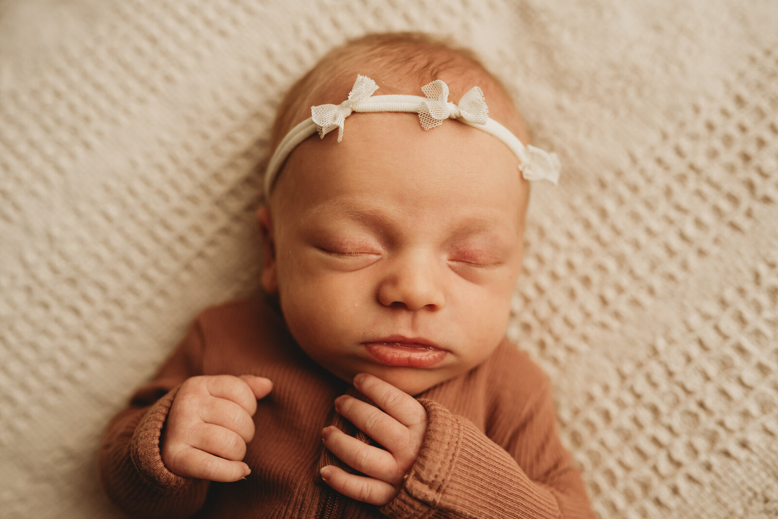 A baby girl wiggles while sleeping,