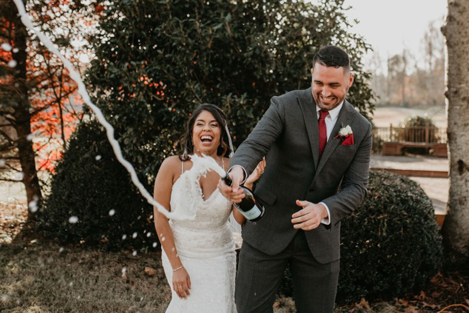 Groom popping champagne at North Carolina destination wedding