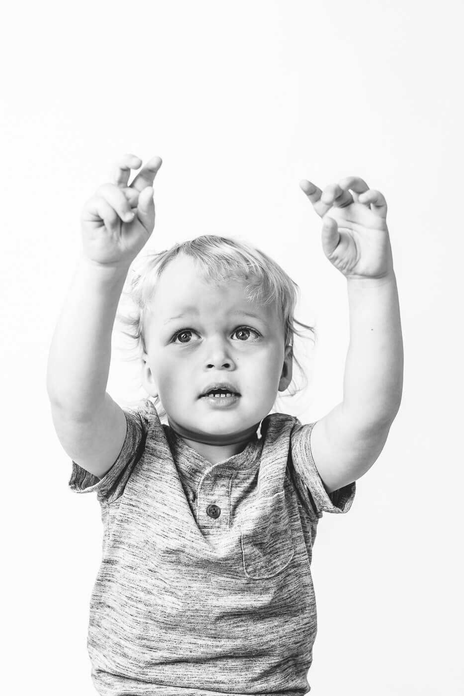 Boy reaching up to grab an imaginary object