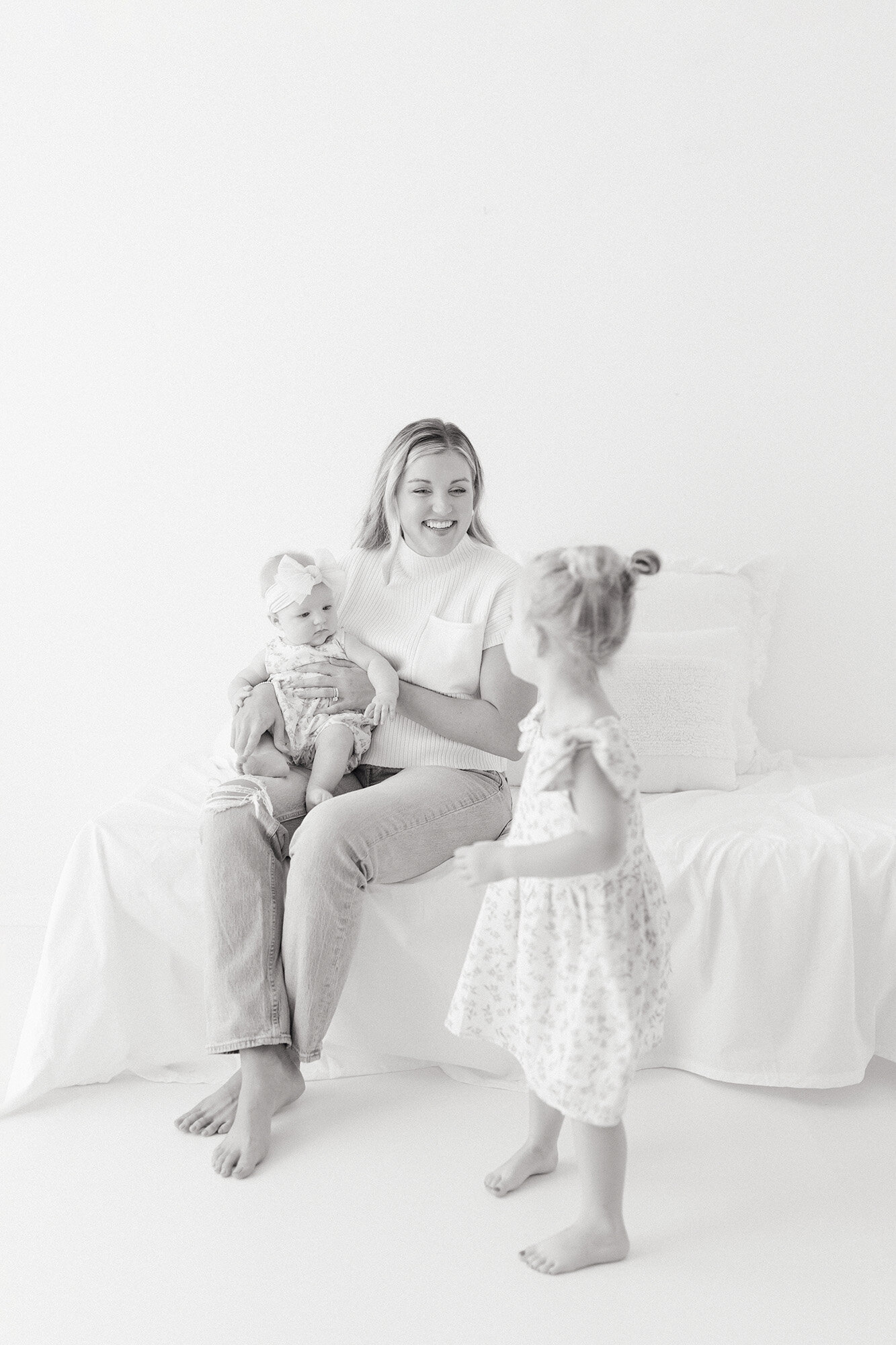 Mother holding her baby while laughing with her toddler during a  family photography session in Grand Forks North Dakota