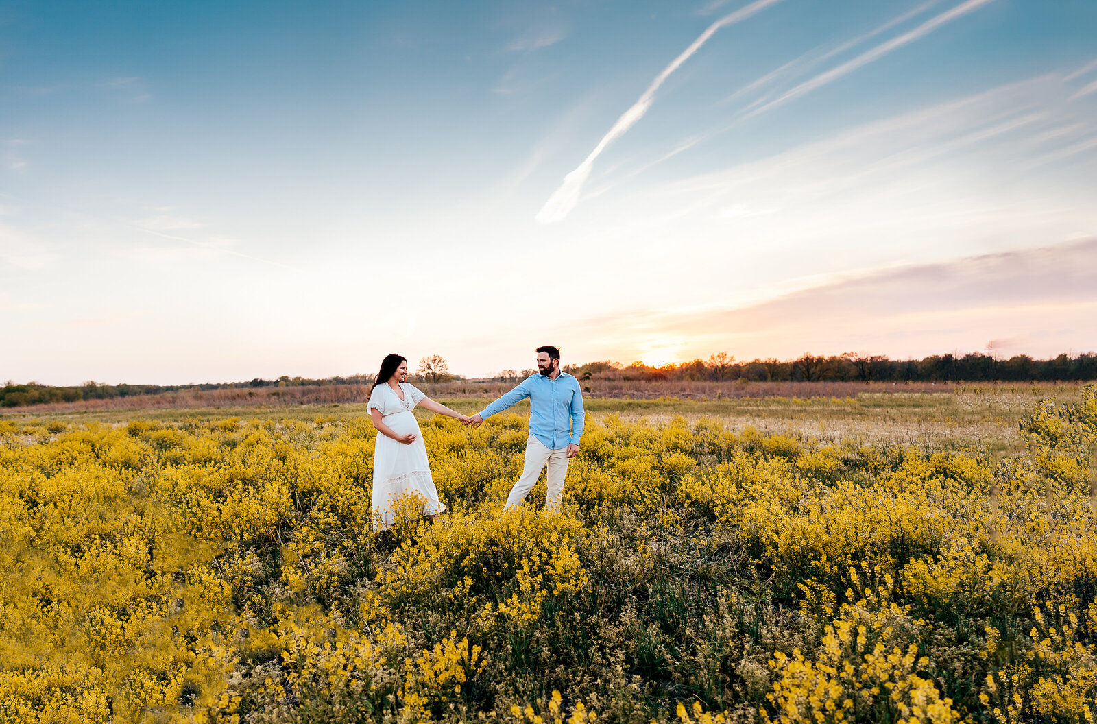 couple walking together through yellow flower field
