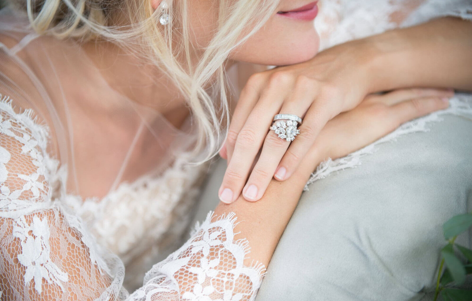 focus on brides ring on her folded hands