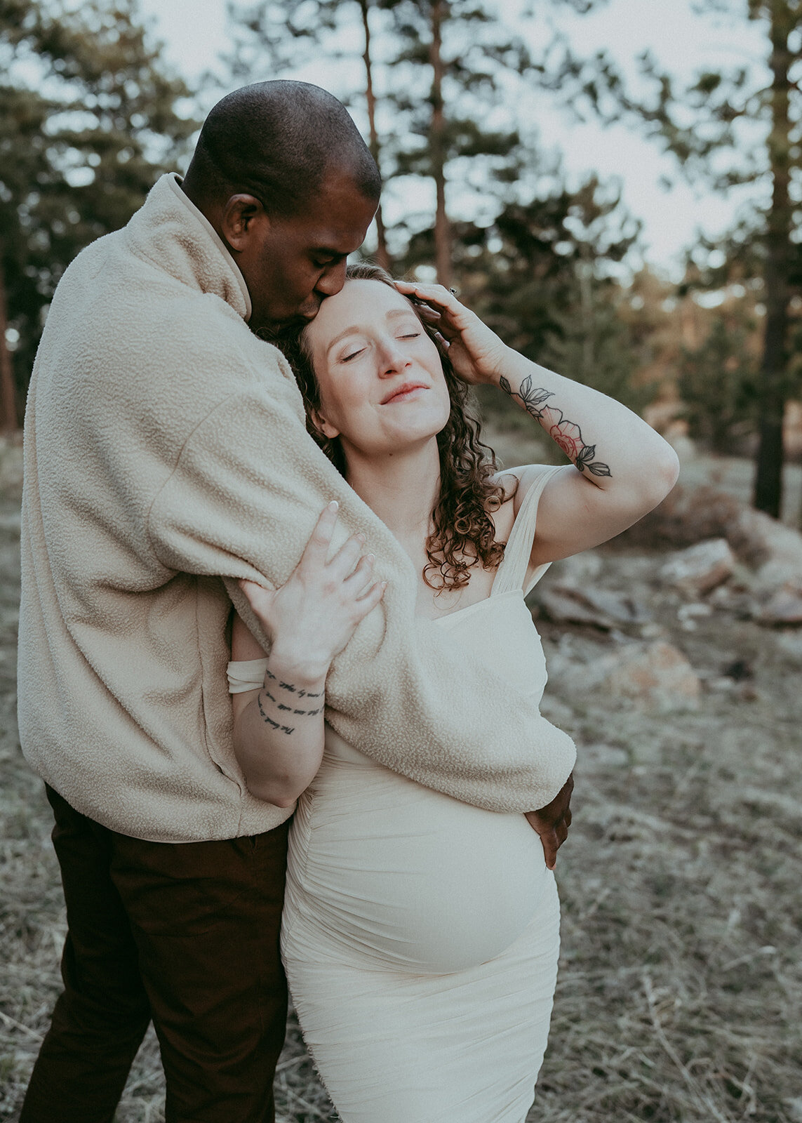husband pulls pregnant wife close for kiss