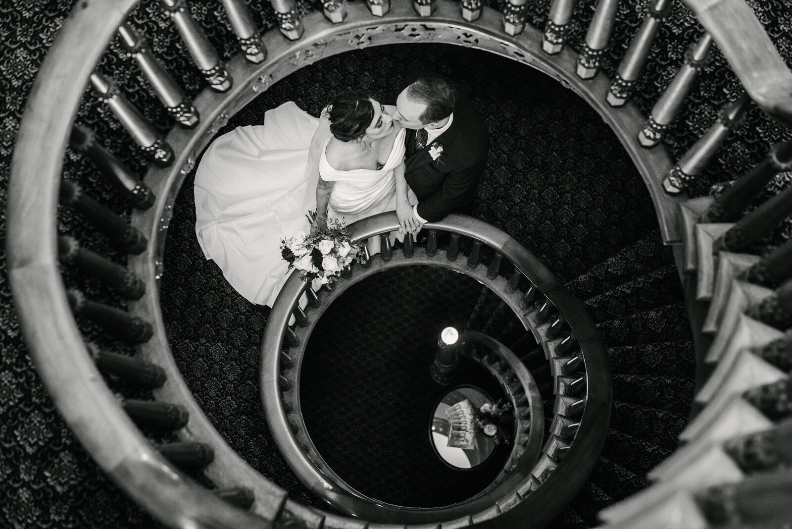 black and white photo of bride and groom on spiral staircase at Mansion Hill Inn