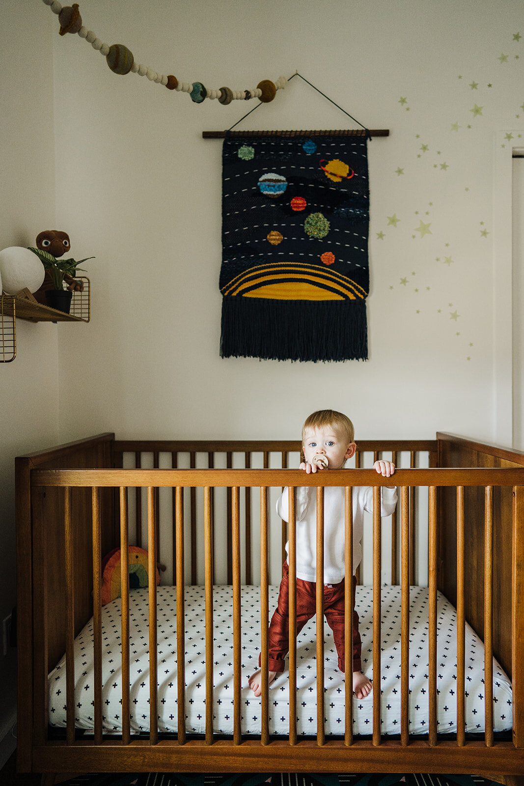 toddler stands in crib