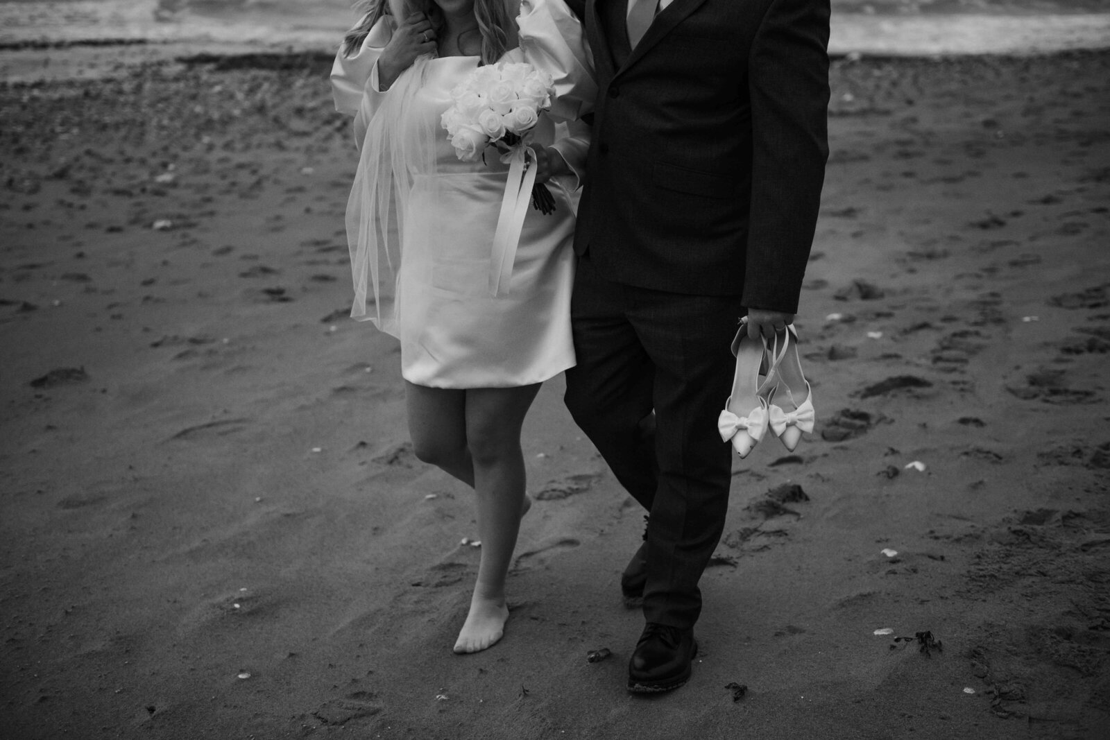 Bride and groom walking on the beach during their couple shoot