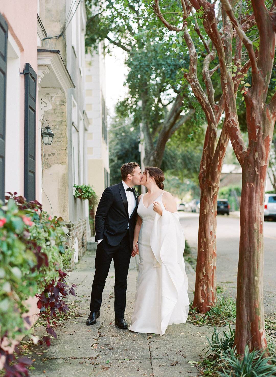 Bride and Groom Kissing On Sidewalk at The Parsonage