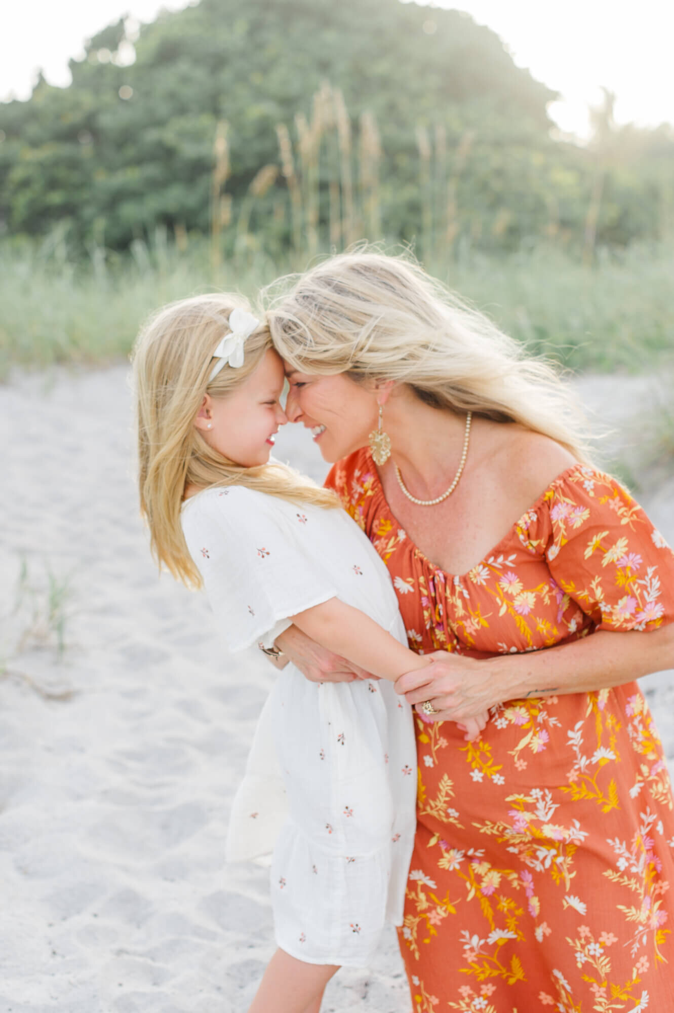 Grandma giving her granddaughter eskimo kisses with a beautiful sunset in the background during their Orlando family photography session