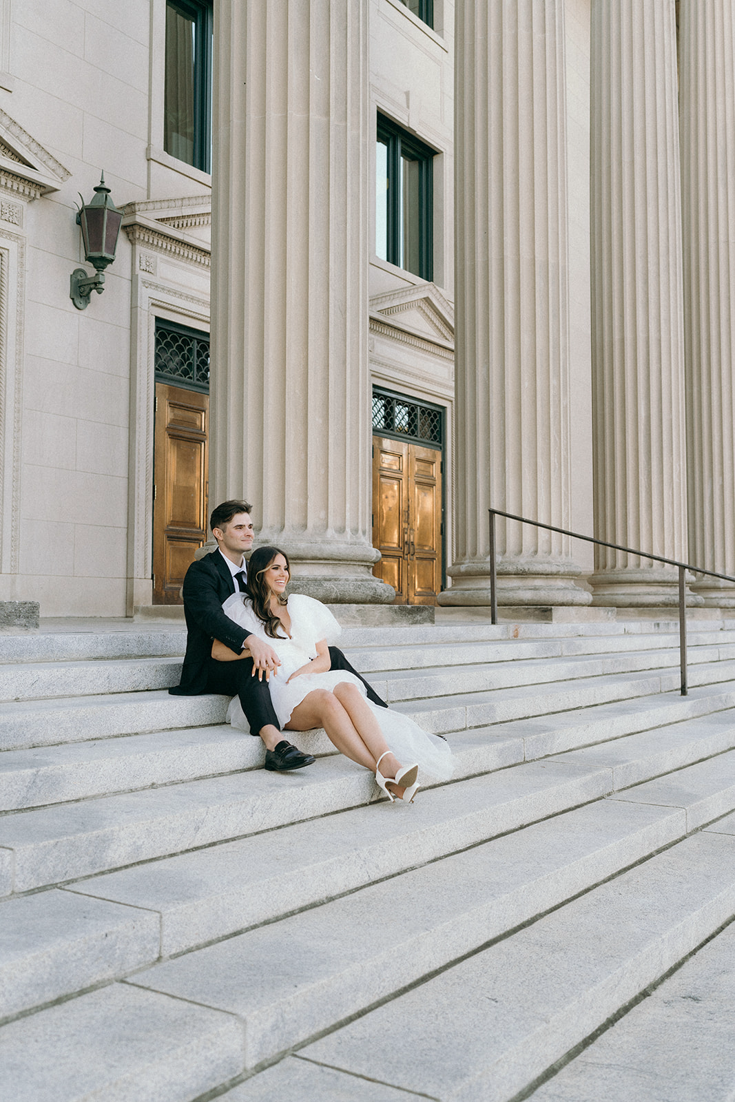 Casual bride and groom sitting together happily at the courthouse steps after getting married in NC | Megan Smith Photography