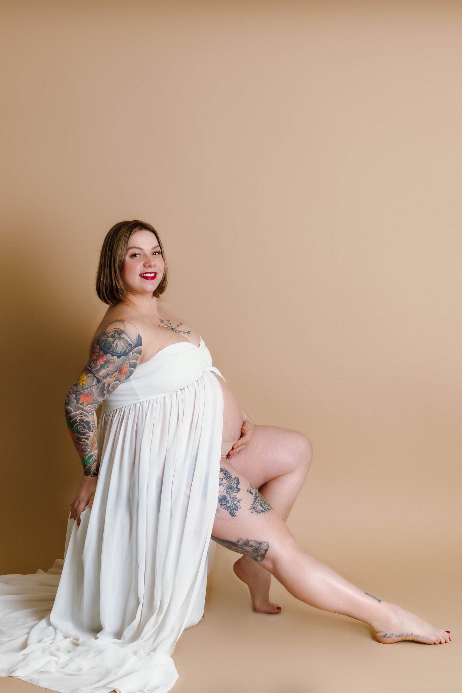 Maternity Photographer, a woman has her belly exposed and tattoos on her skin, she is pregnant