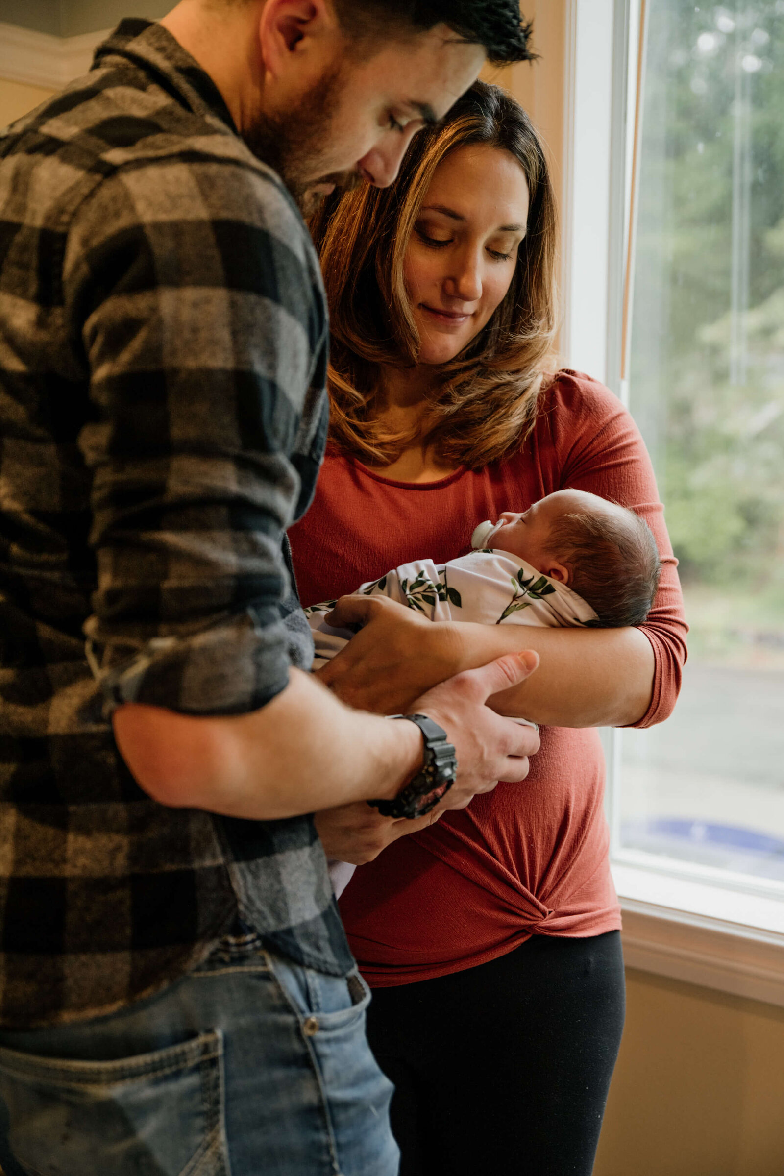 Couple holding baby in their arms.