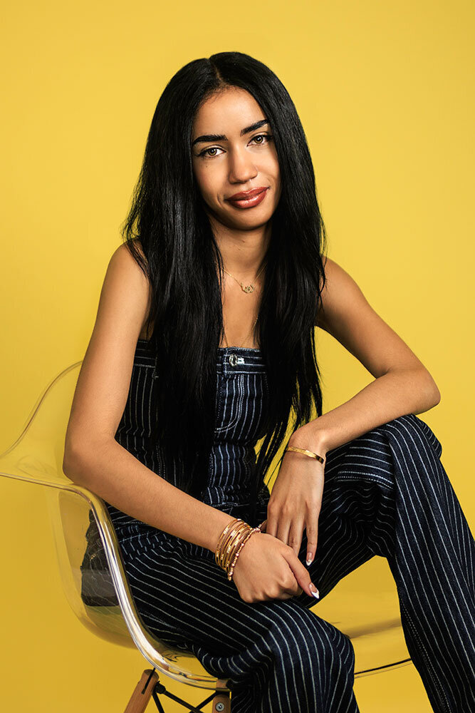 yellow-background-colorful-creative-positive-senior-high-school-studio-blue-jump-suit-modern-artsy-edgy-clear-chair-professional-portrait