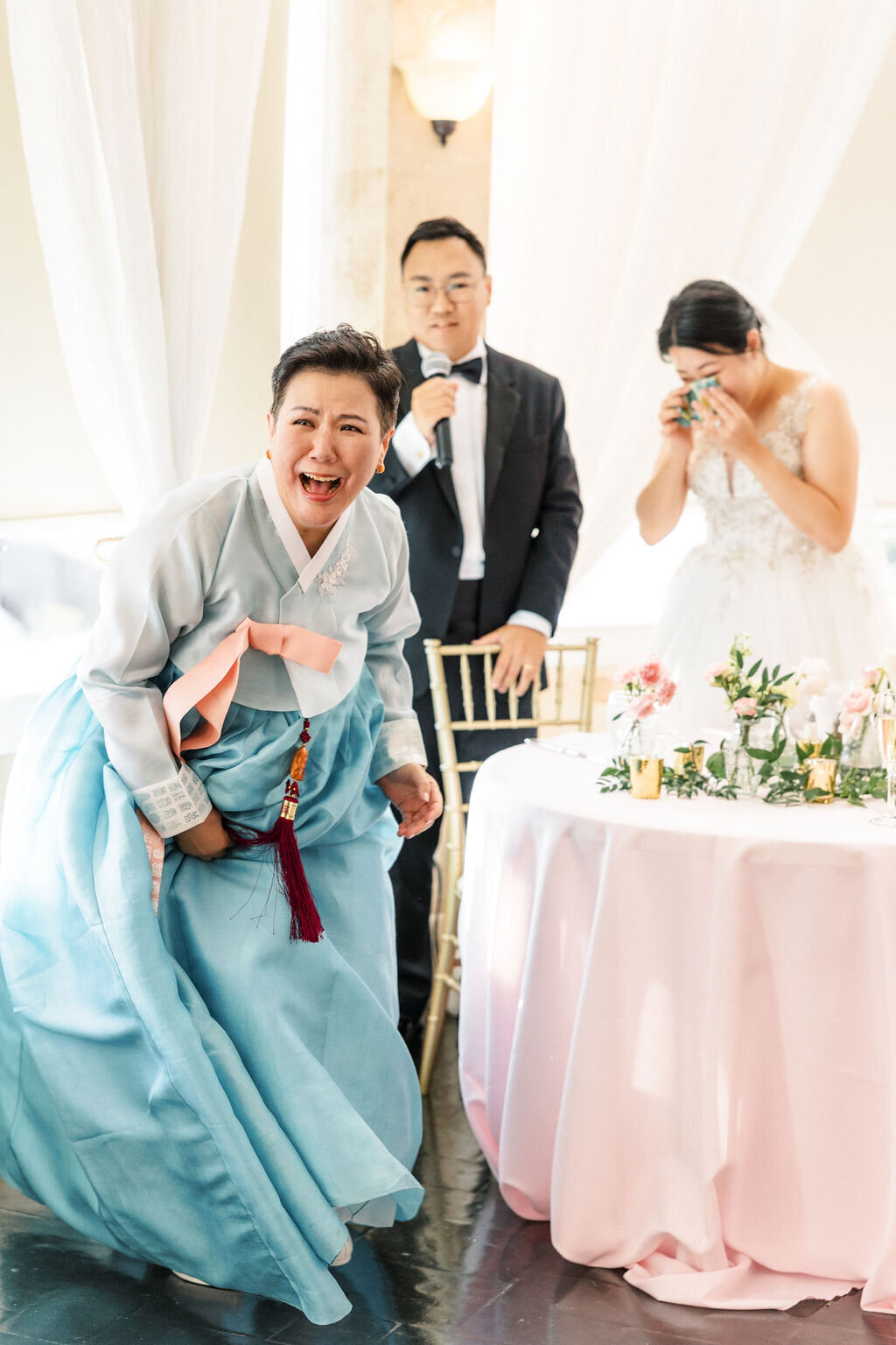 Mother of bride in blue oriental asian dress cries at wedding