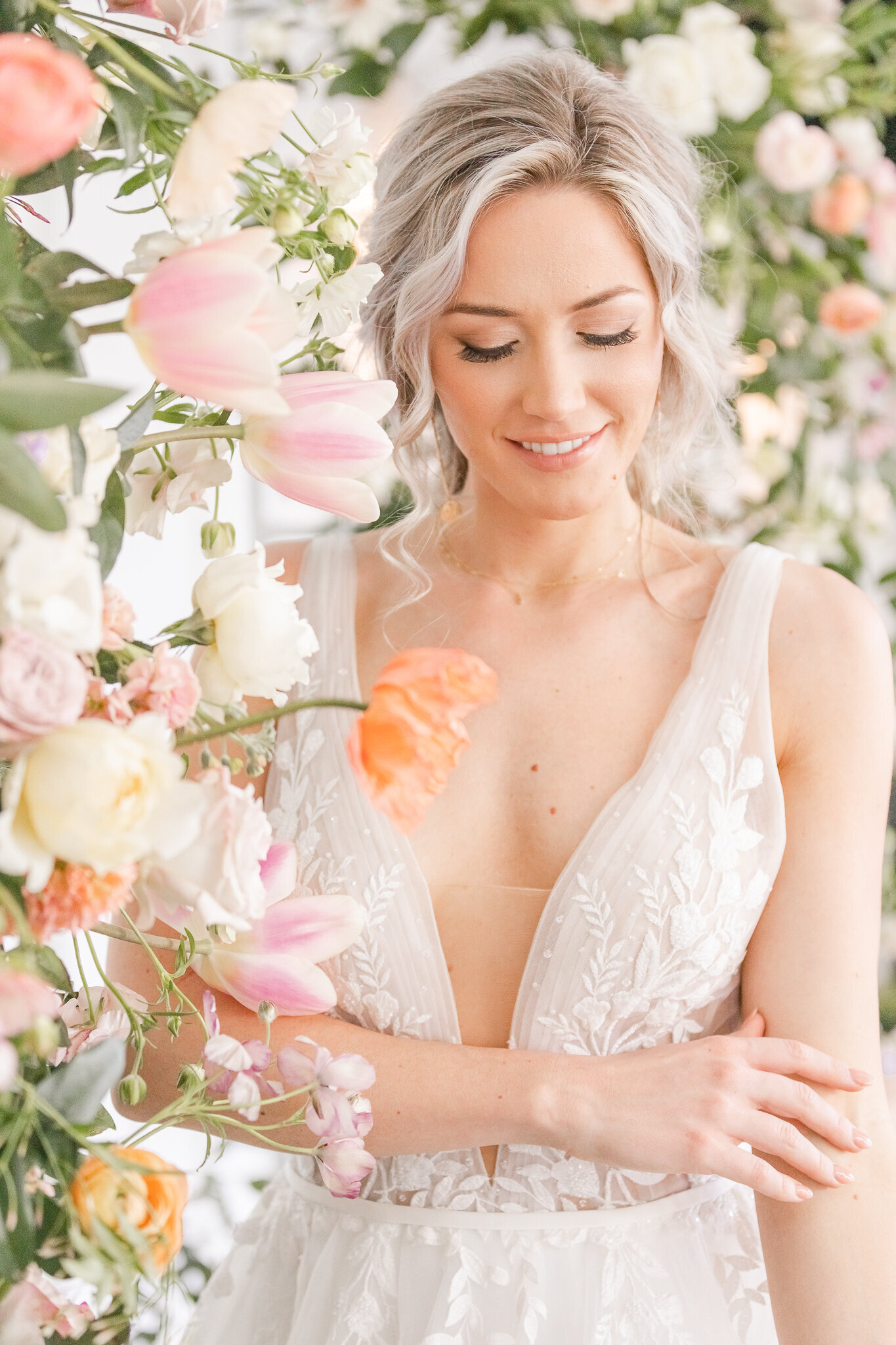 bright light and airy wedding photo of bride  in floral arch