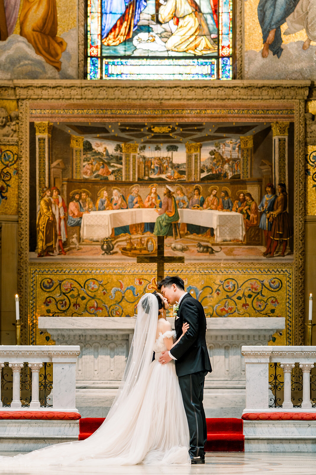 The bride and groom stand before the stunning altar at Stanford Memorial Church, capturing a moment of unity and love.