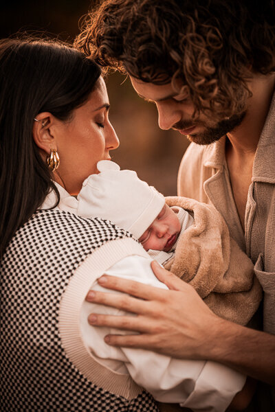 Een newborn fotoshoot in de natuur, omringt door de ouders en trouwe hond