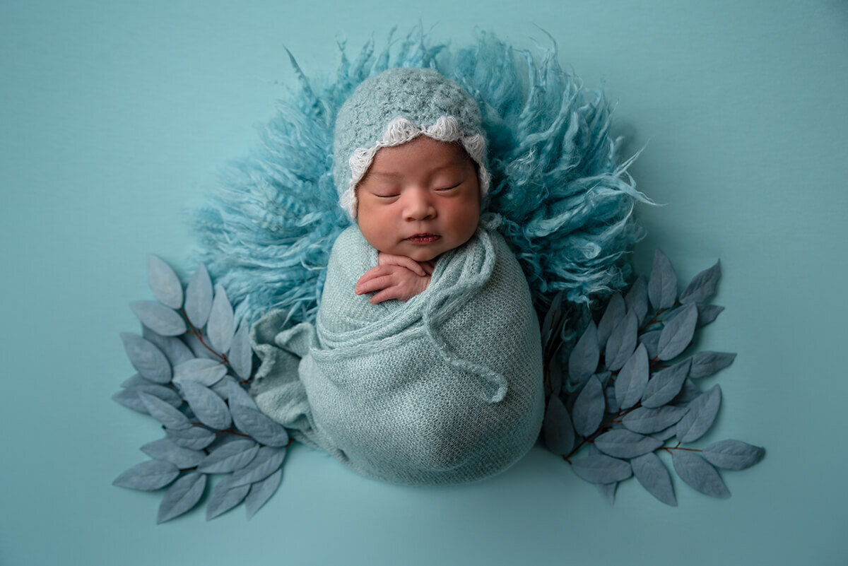 newborn baby wrapped in blue