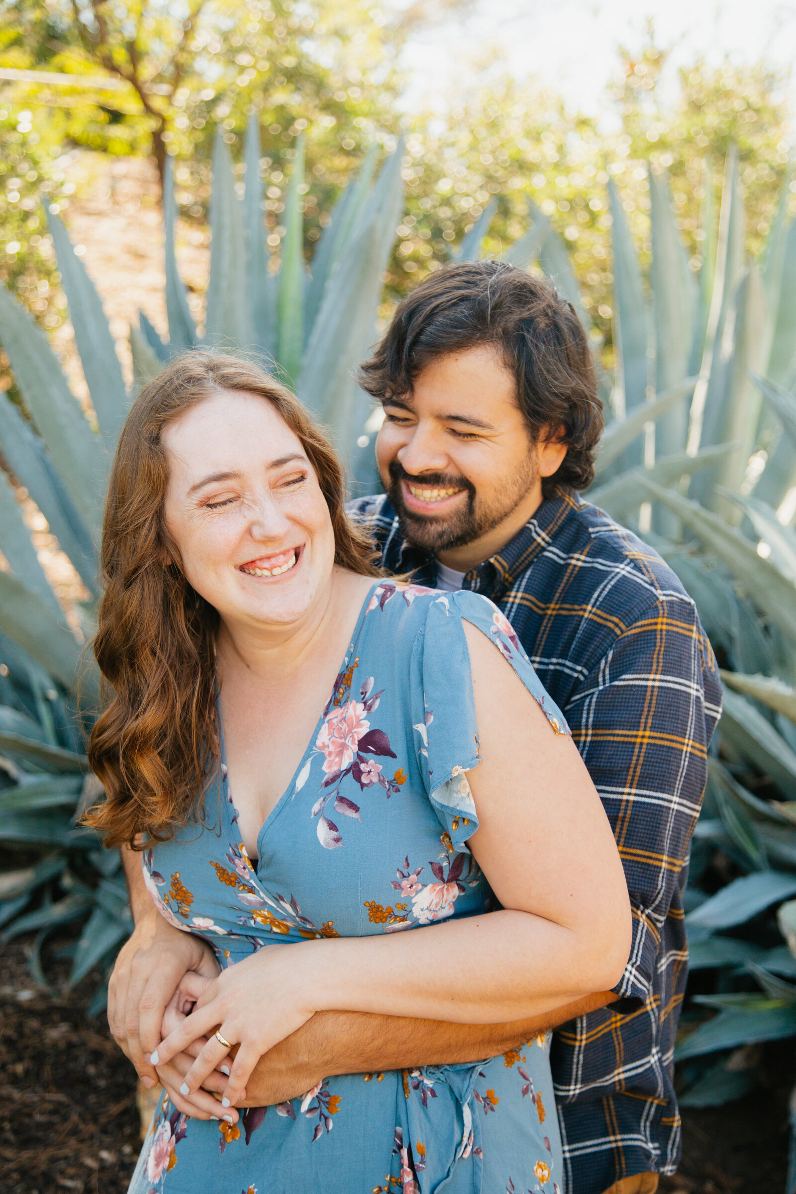 An engaged couple poses for photos in a garden in Los Angeles, Ca.