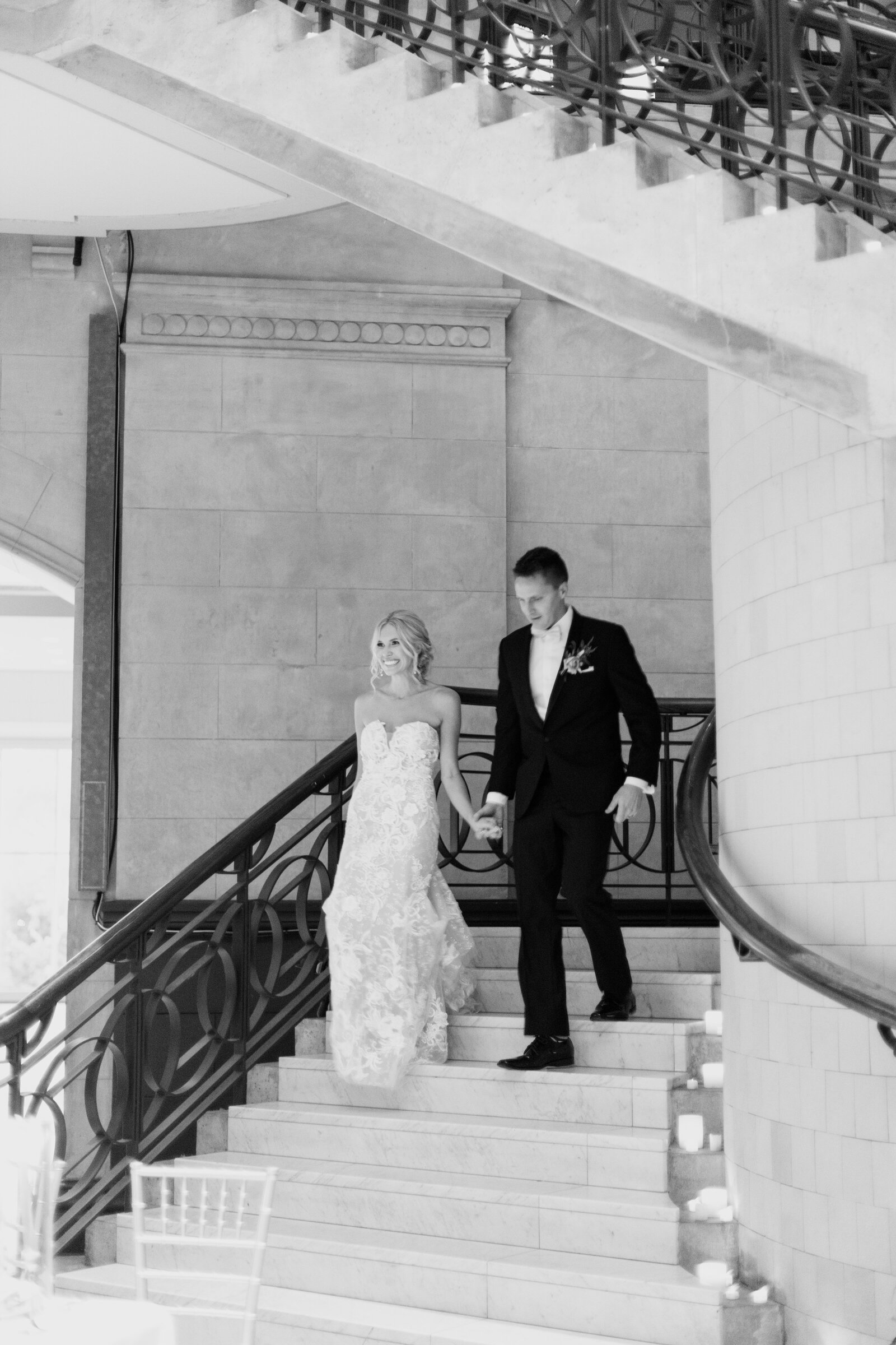 bride and groom walk down staircase
