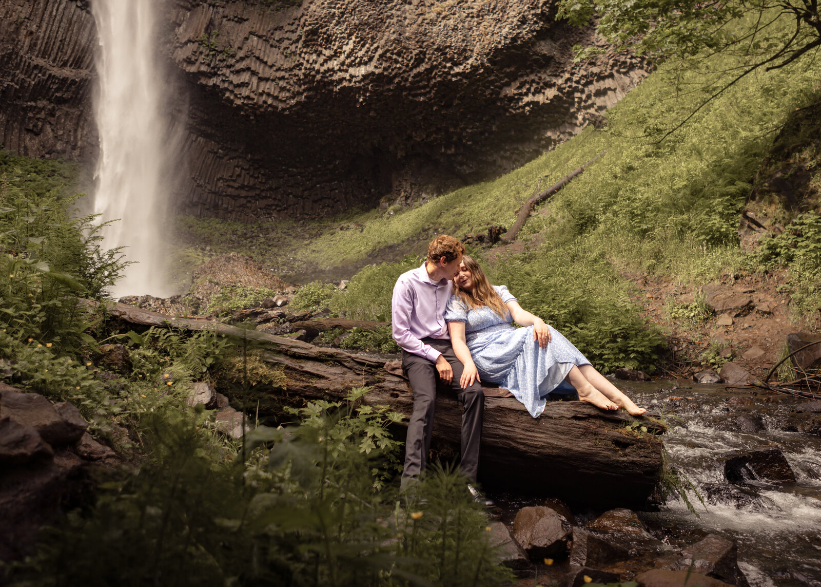 Couple sitting on log near latourell falls in the columbia gorge