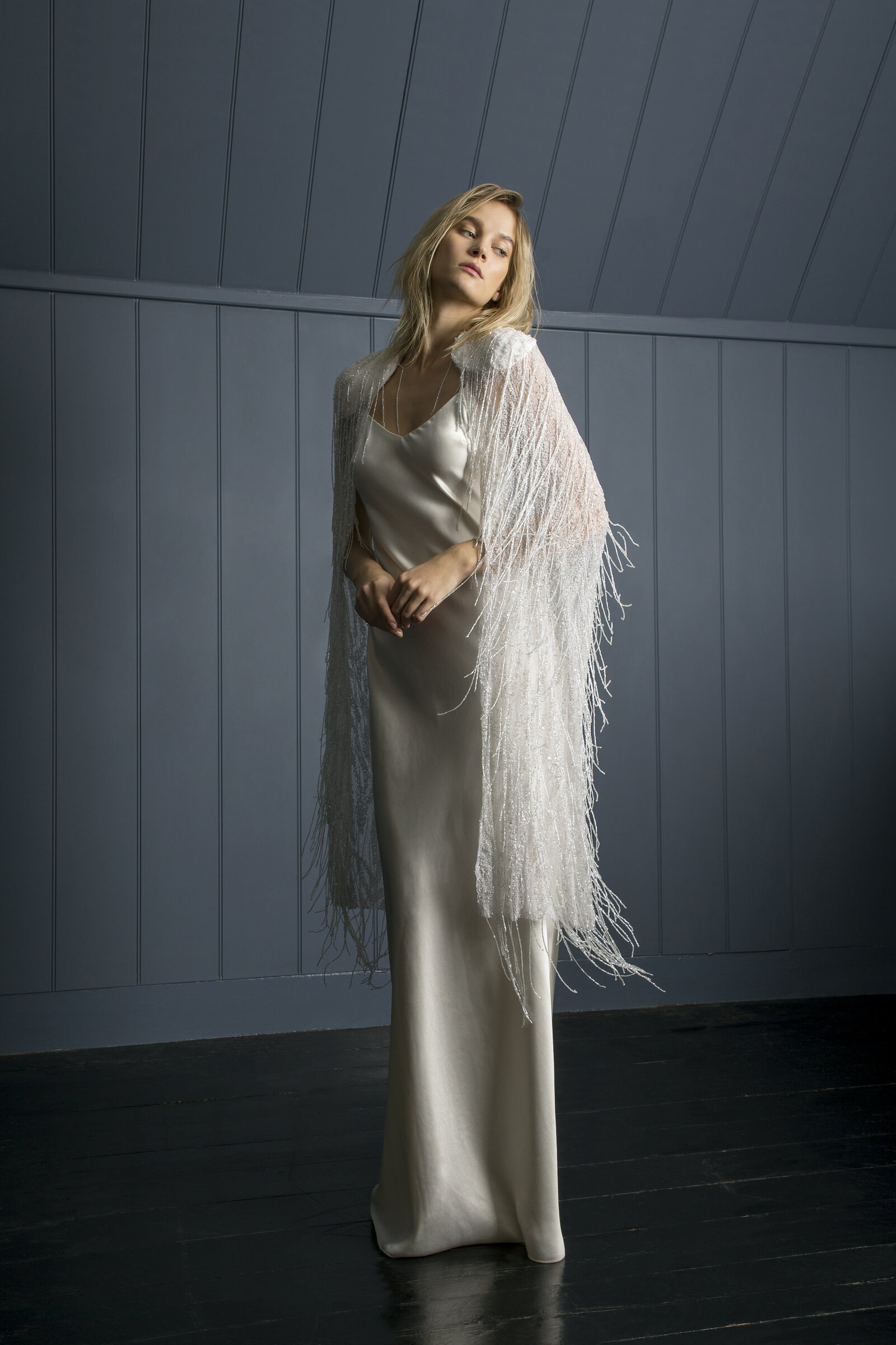 bride wearing white satin wedding dress with feathered cloak