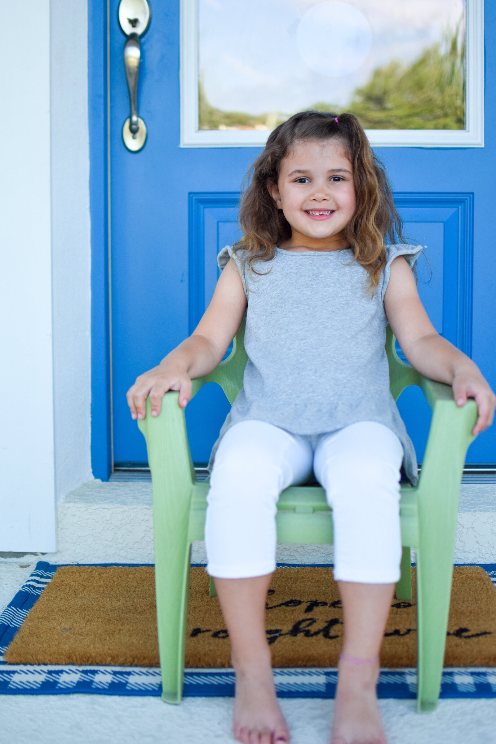 little girl green chair blue door Front Porch Project Oakland Florida