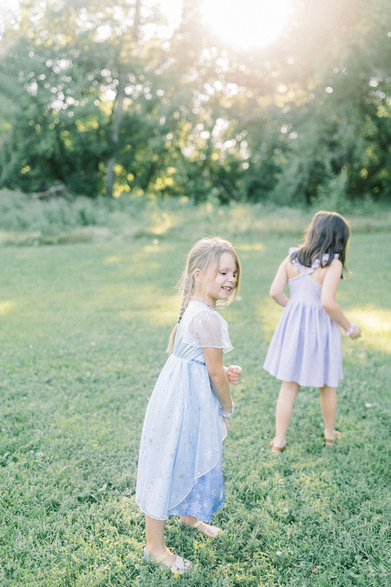 A candid moment of two sisters running in a field during their sunset family photos at Turtle River State Park 