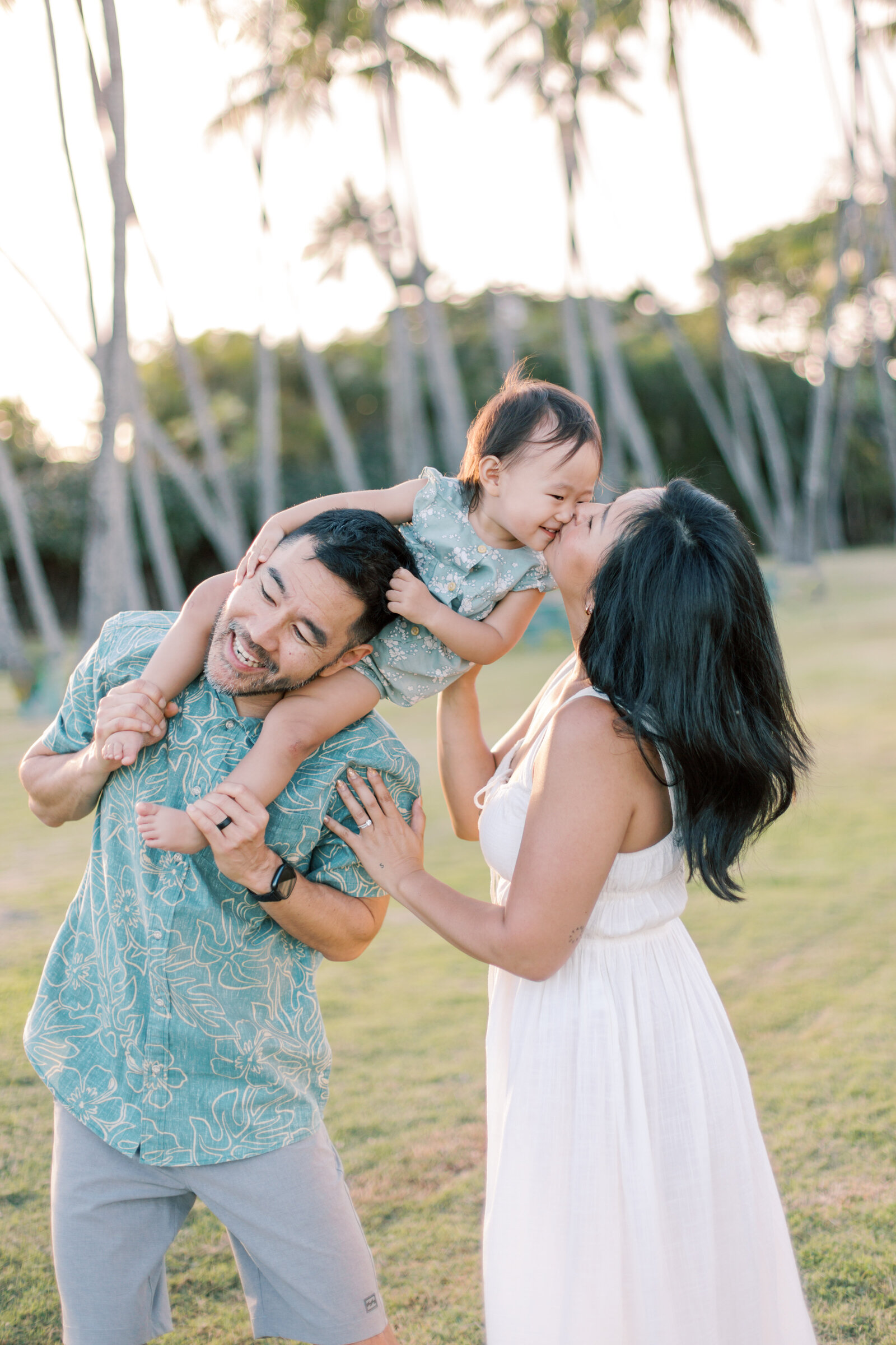 family kissing and playing at park taken by family photographers spokane