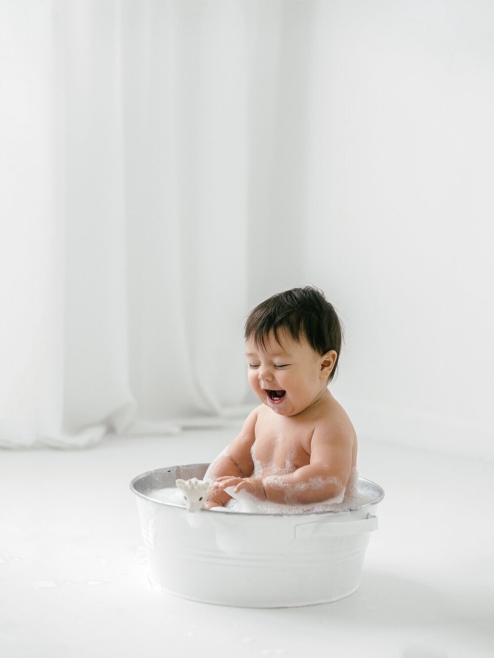 Older baby photoshoot with  baby laughing in the bath