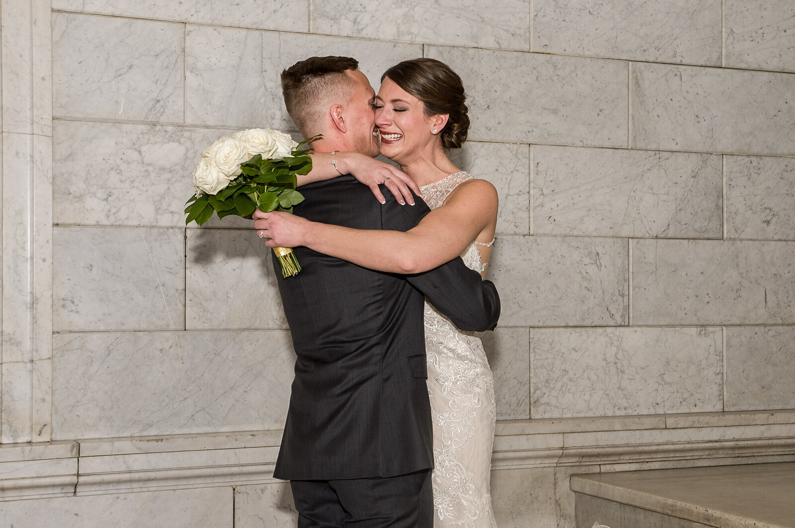 Bride and groom hug crying at Lumber Exchange Building in Minneapolis, Minnesota.