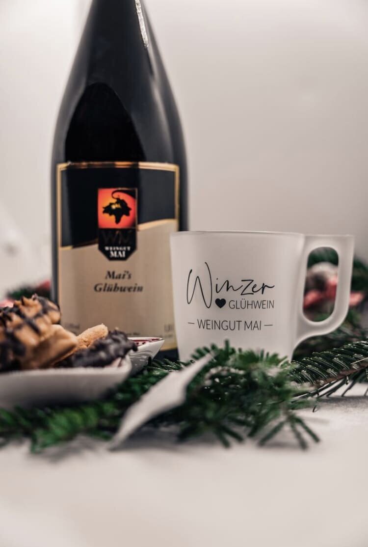 winterliches Foto mit weißer Glühwein-Tasse, Glühwein-Flasche und Plätzchen