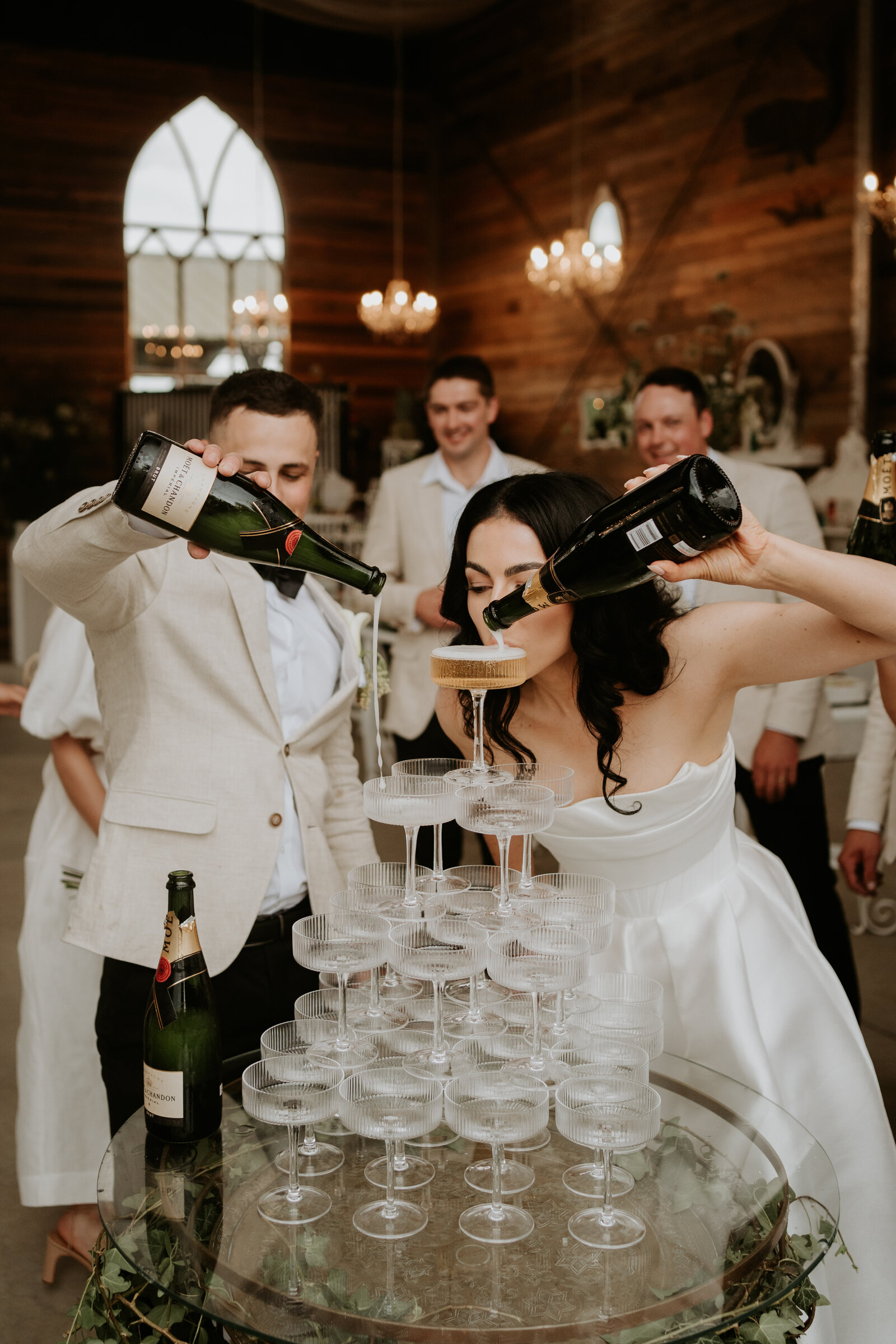 Bride and groom using champagne tower 