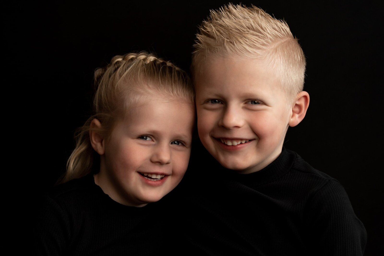 Baby portretfoto met moeder en zwarte achtergrond.