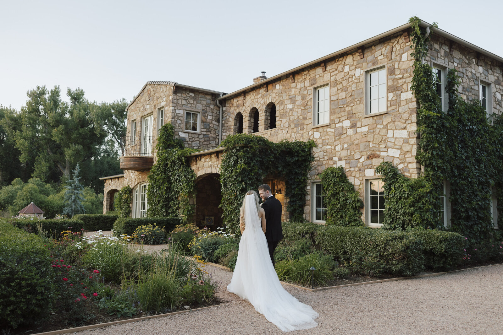 Bride And Groom Walk In Front Of The House At Burning Sky Ranch in Longmont, Colorado