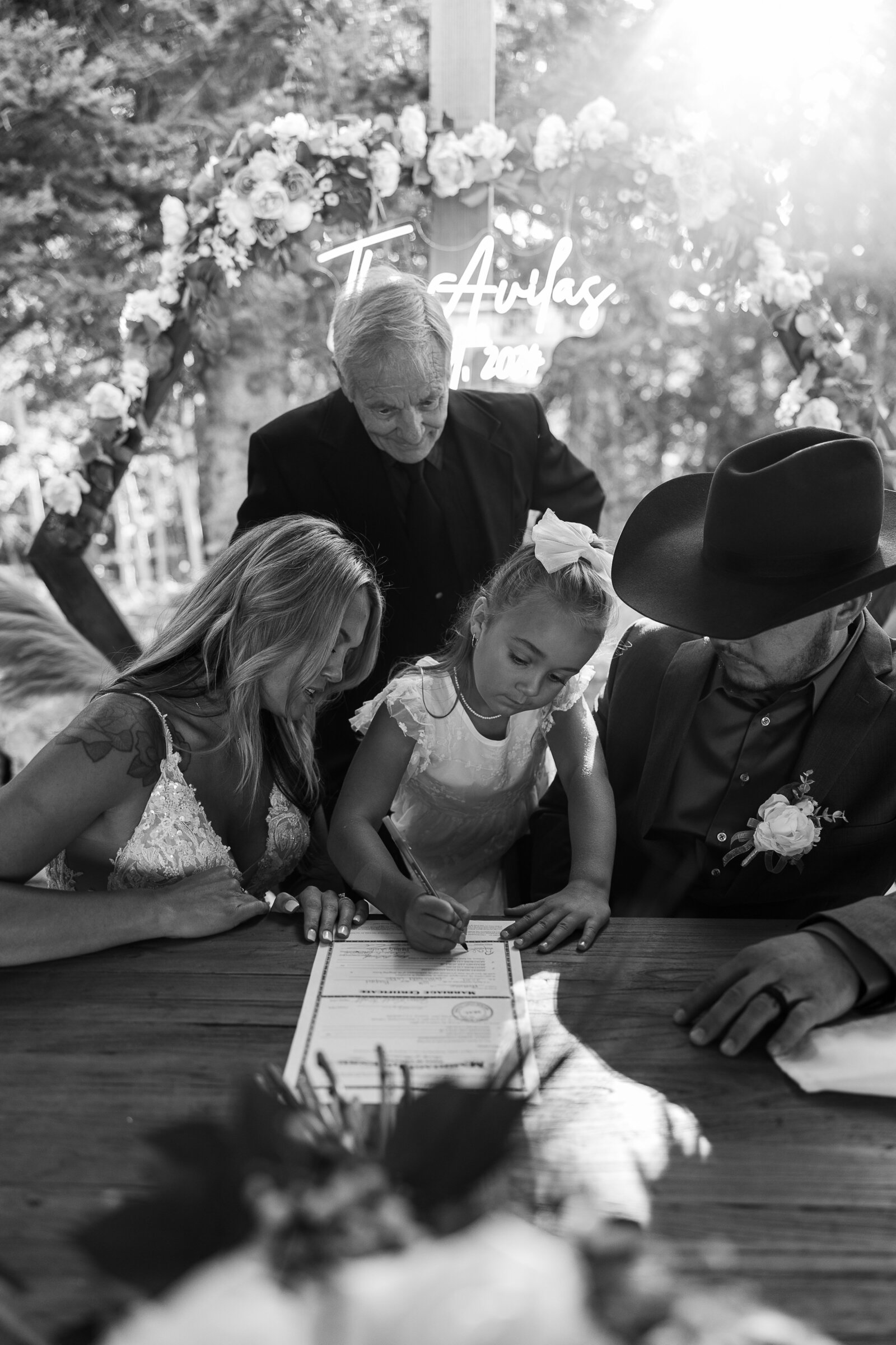 Grooms daughter signs the marriage license after wedding at Arrowhead Lodge