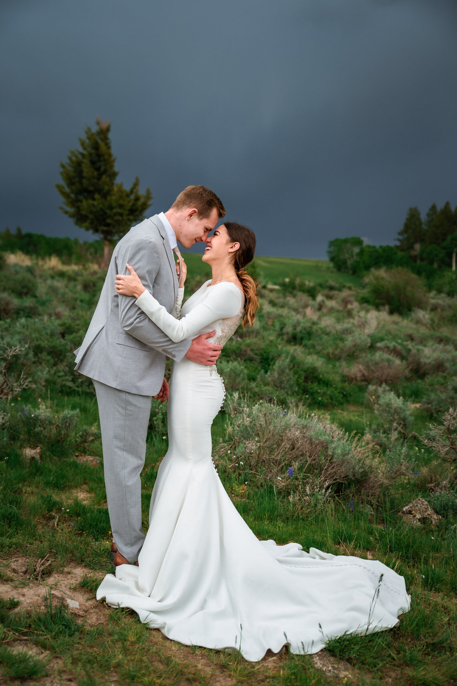 Jackson Hole photographers capture couple hugging and kissing during golden hour portraits