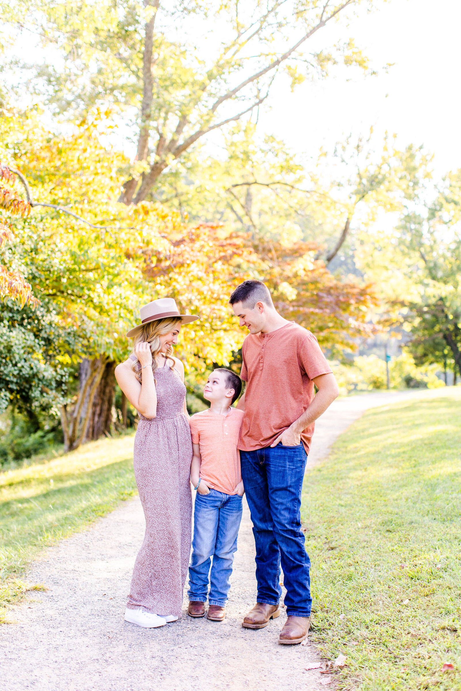 girl with hat on and boyfriend looking down at son