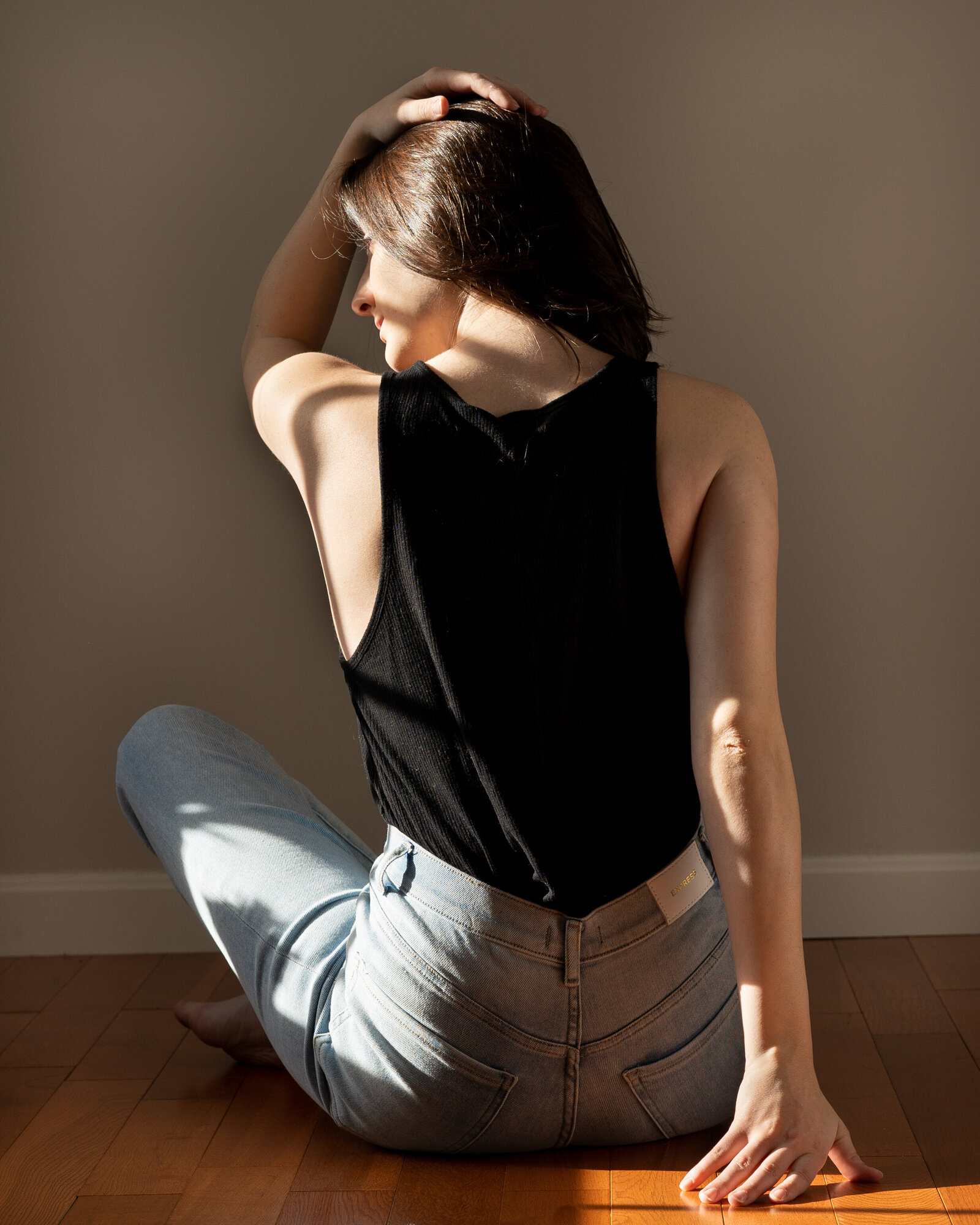 Woman wearing a black shirt and blue jeans during a portrait photography photoshoot.