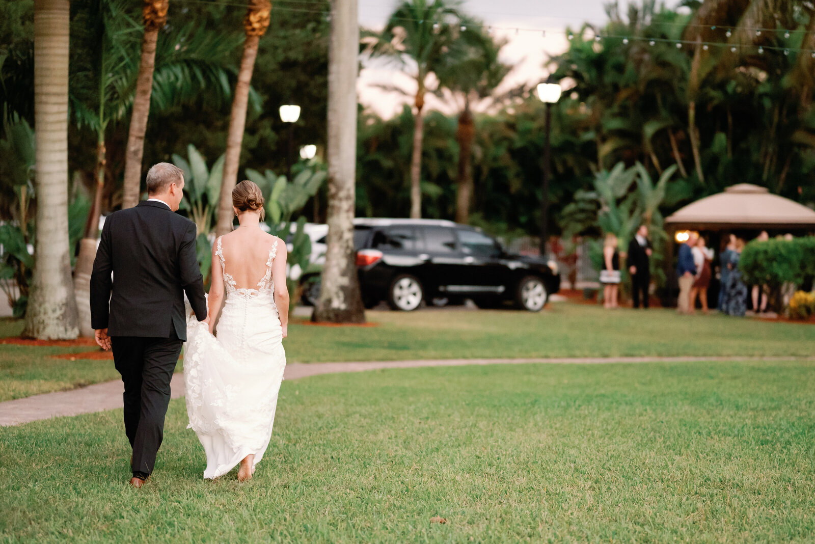 bride and groom walking back toward their wedding venue ready to be introduced to their reception