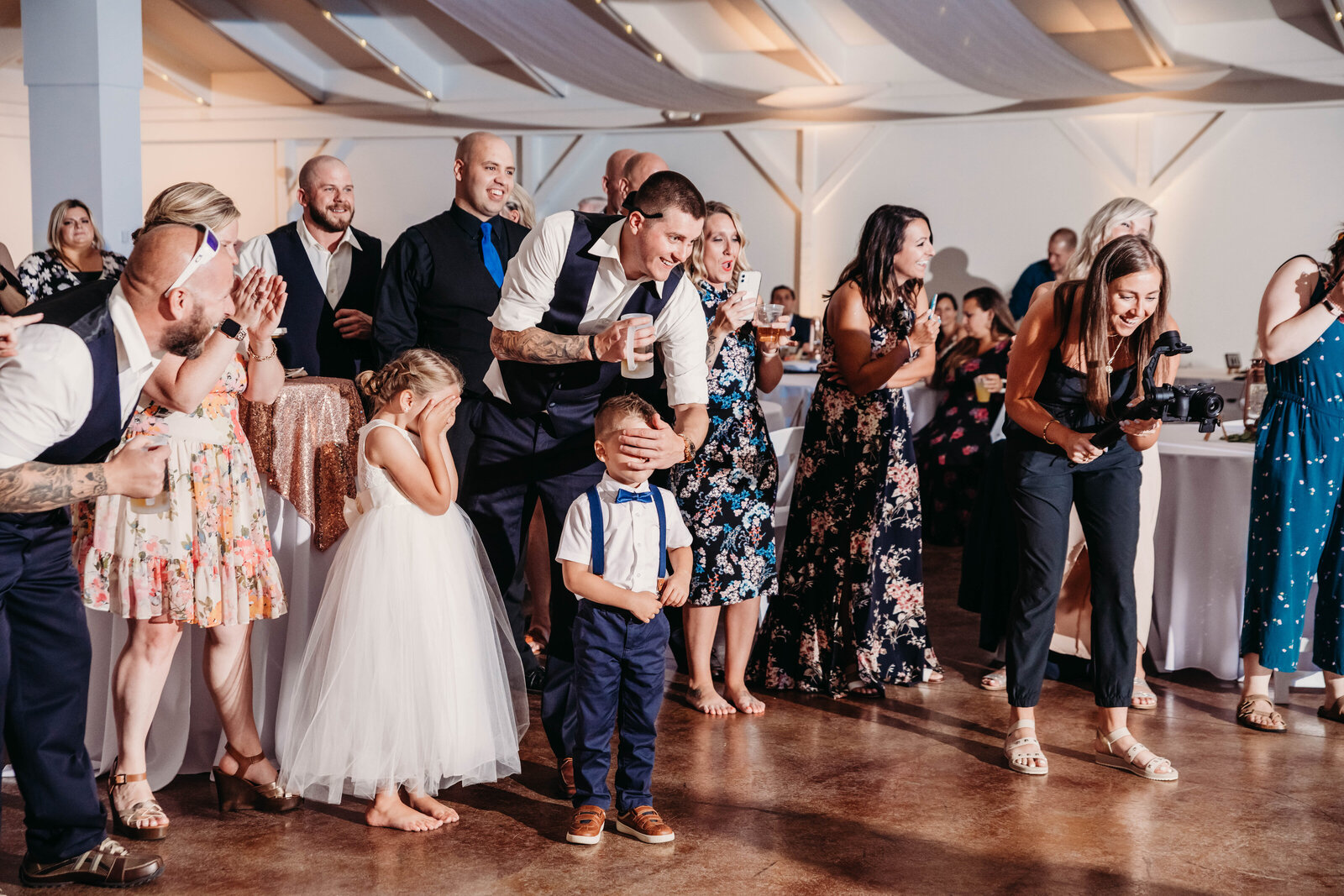 Kids close their eyes at the garter toss time of reception..