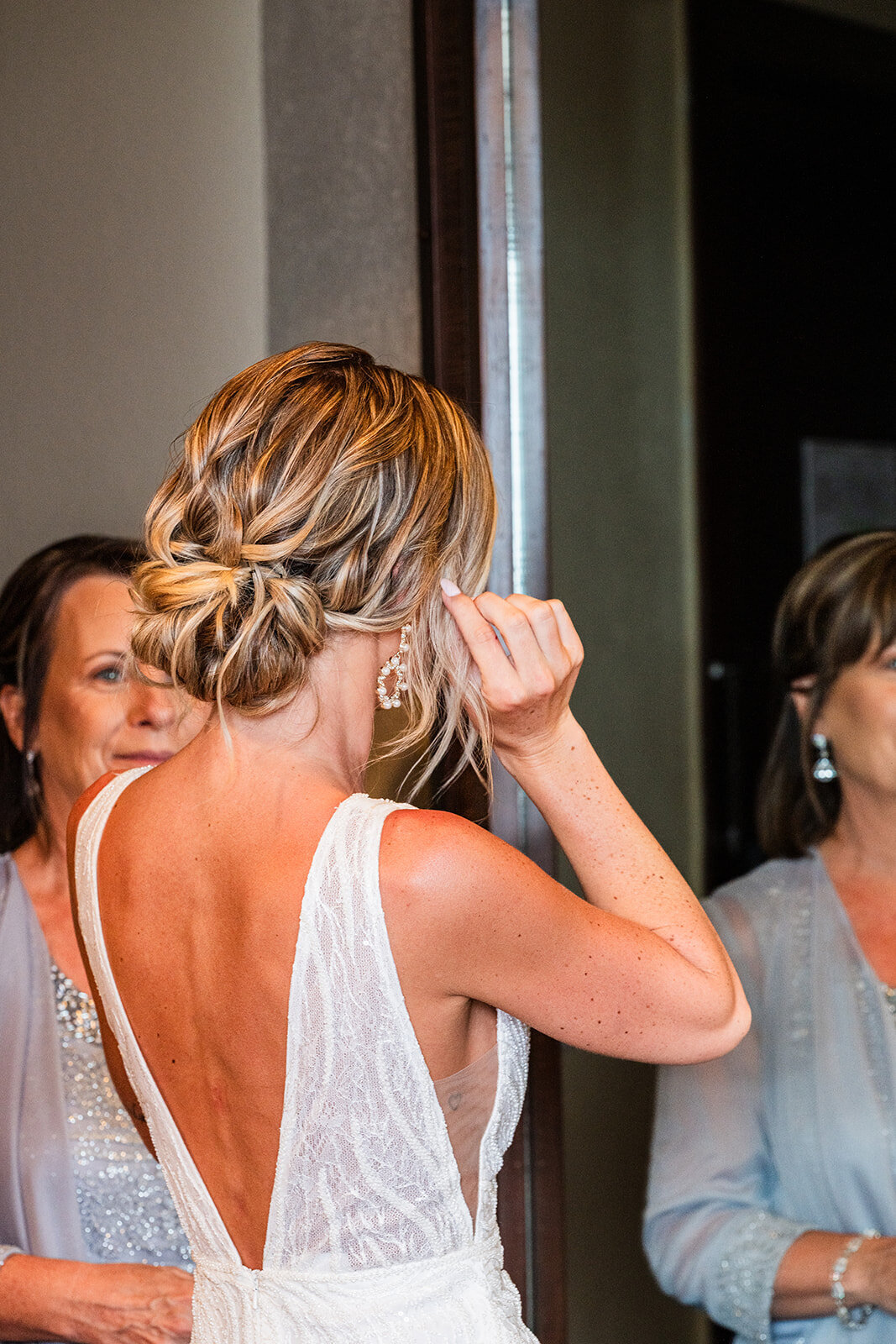 The bride receiving final makeup touches on her wedding day, captured in a candid, behind-the-scenes moment by CMH Studios.