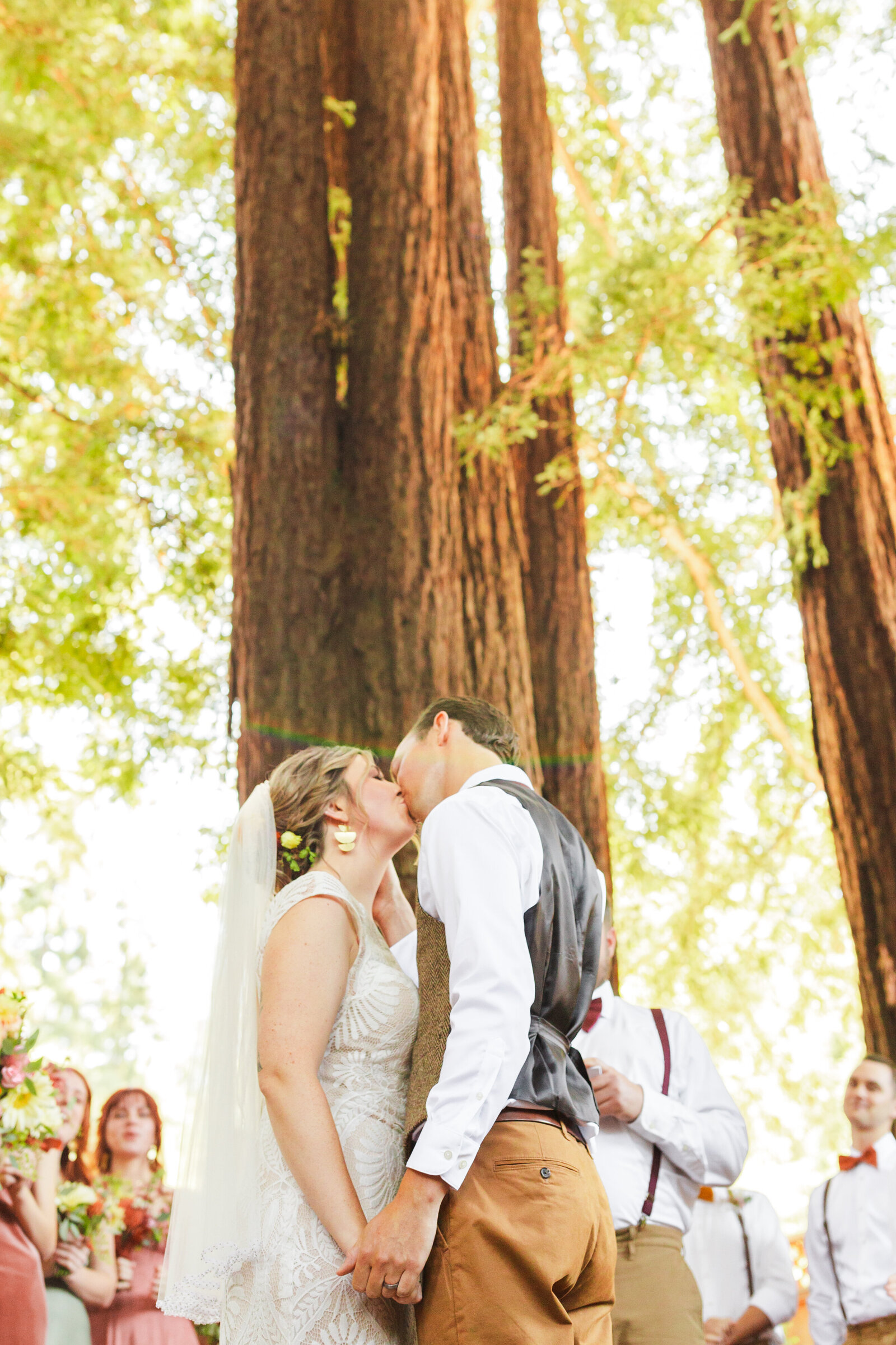 Bride and groom at their colorful wedding ceremony in Santa Cruz, California in the redwood trees.