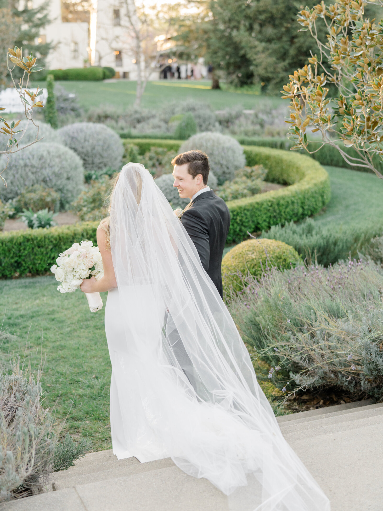 bride and groom holding hands and walking in a garden